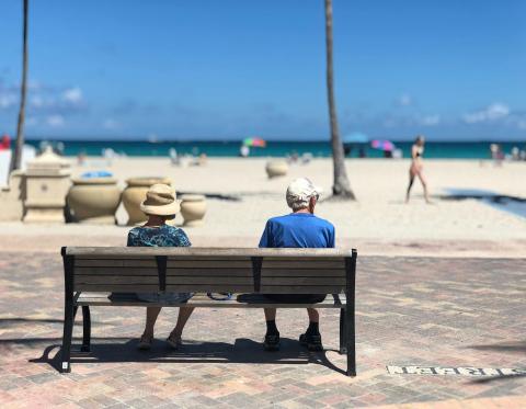 Pareja mayor descansando en un paseo marítimo